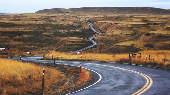 Winding road through rolling hills, symbolizing the journey of AI in business and its transformative impact on industries.